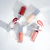 Quatro glosses labiais Lara Beauty em diferentes cores com aplicadores e amostras de brilho ao lado