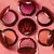 Vários blushes da Guerlain Terracotta em diferentes tonalidades dispostos sobre uma superfície rosa.