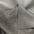 Textura de telas en tonos grises, mostrando una superficie lisa y otra con un patrón de malla.