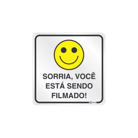 Placa de sinalização com fundo branco e desenho de um sorriso, com a frase 'Sorria, você está sendo filmado!'