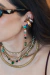 Brinco Lumina Multicolor Médio Dourado, com pedras coloridas, usado por uma mulher que também usa colares dourados.