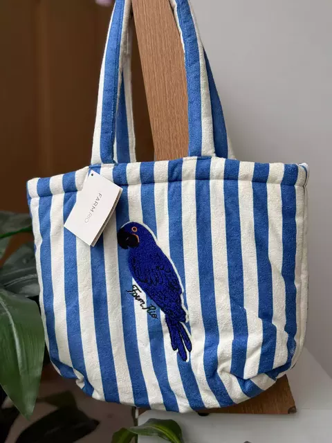 uma bolsa azullistrada com arara bordada