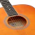 Guitarra acústica SX SD104BR en detalle del plano medio superior del cuerpo. Se distingue la boca con roseta de líneas blancas y negras, la etiqueta interna de SX Custom Guitars, cuerdas de bronce 80/20 y los trastes Jumbo del diapasón.
