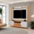 Rack para TV con panel Helo de 183 cm en tonos Freijo y Off White, apto para televisores de hasta 75 pulgadas, con puertas corredizas, estantes y detalles modernos en un living contemporáneo.