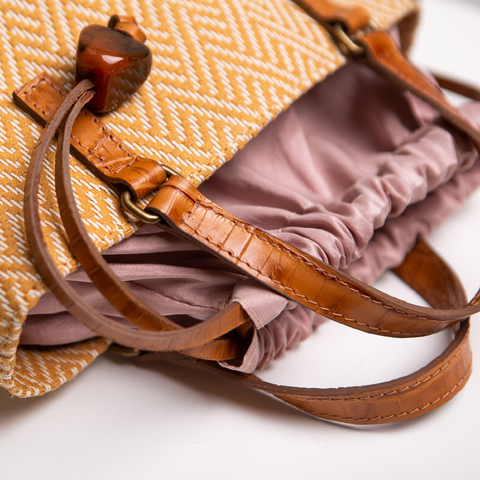 Bolsa Babi em palha com alças de couro caramelo e fechamento interno em tafetá rosa claro