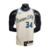 Regata Basquete NBA Milwaukee Bucks da Nike na Cor Bege com a logo da Nike no lado direito da Regata, gola careca com detalhes nas cores azul e preto, estampas nas cores preta  e azul nas costas fica a logotipo da NBA na parte da nuca.