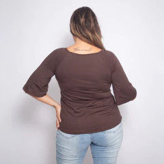 Vista trasera de una mujer usando una remera marrón de manga corta.