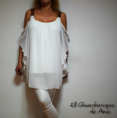 Blusa Bella blanca con mangas caídas y detalles en los tirantes, modelada por una mujer.