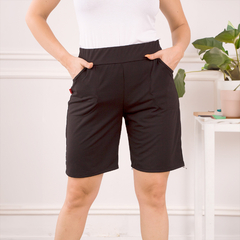 Pantalones bermuda negros con dos bolsillos, modelo Bermuda Blu, usados por una mujer en un entorno luminoso.