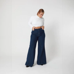 Modelo vistiendo jeans Gotic de corte amplio en color azul oscuro, combinados con una blusa blanca ajustada.