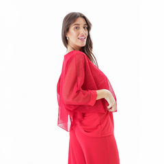 Modelo luciendo una blusa roja Aike con mangas transparentes y detalles brillantes.