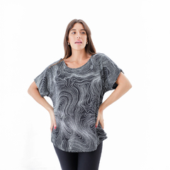 Blusa Ailen de color negro con diseño de líneas onduladas blancas, modelo femenino, con mangas amplias.