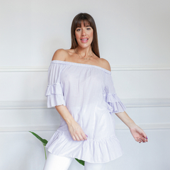 Modelo luciendo una blusa de rayas lilas con mangas acampanadas y un diseño fresco.