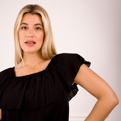 Modelo luciendo una blusa negra de estilo Brigitte con mangas cortas y detalles en el escote.