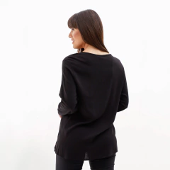 Mujer con blusa negra vista desde atrás.