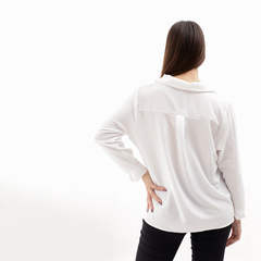 Vista posterior de una blusa blanca con un diseño simple y elegante, ideal para usar en diversas ocasiones.