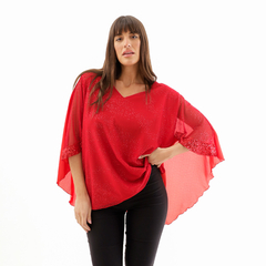 Blusa Erea roja con mangas amplias y detalles brillantes, combinada con pantalones oscuros.
