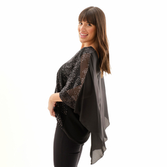 Blusa Erea negra con detalles brillantes, modelo posando de perfil y sonriendo.