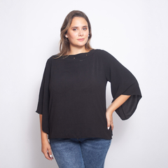 Blusa Felisa de color negro con mangas amplias, modelo femenino posando frente a una pared blanca.