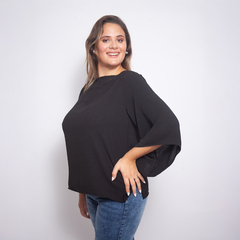Modelo luciendo una blusa negra de manga amplia llamada Felisa, sonriendo hacia la cámara.