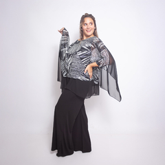 Modelo luciendo una blusa Georgina con diseño en blanco y negro, combinada con falda negra, en un fondo blanco.