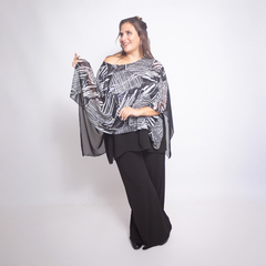 Modelo luciendo una blusa Georgina de estampado en blanco y negro, combinada con pantalones negros.