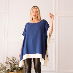 Modelo luciendo una blusa elegante de color azul marino con detalles en blanco, combinada con pantalones de cuero.