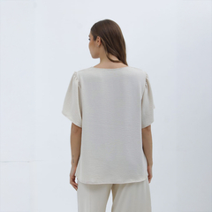 Vista trasera de la blusa Nalani en color beige, con mangas cortas y diseño ligero.