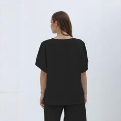 Blusa Nalani negra vista desde atrás, con mangas cortas y diseño sencillo.