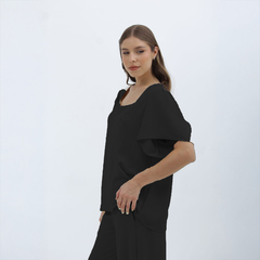 Modelo luciendo una blusa negra Nalani con mangas amplias y escote cuadrado.