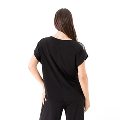 Modelo de blusa negra Rem vista desde atrás, con detalles en los hombros.