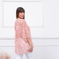 Blusa Siena en color naranja con estampado, vista lateral de una mujer que la lleva puesta.
