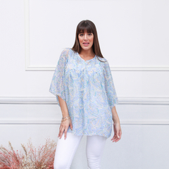 Blusa Siena de estampado paisley en tonos azules, modelo con mangas amplias y escote redondo, combinada con pantalones blancos.