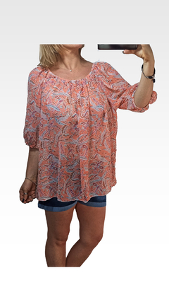 Blusa Tai de color durazno con estampado de paisley, de manga larga y corte suelto, combinada con pantalones cortos de mezclilla.