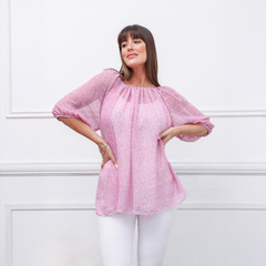 Blusa Tai de color rosa con mangas abullonadas, modelo femenino, posando con una mano en la cadera.