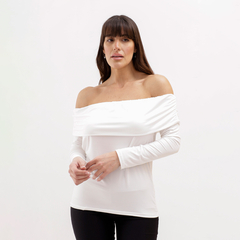 Mujer usando una blusa blanca de hombros caídos, con mangas largas y un diseño ajustado.