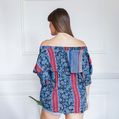 Vista trasera de una mujer usando una blusa Telma con estampado colorido y mangas amplias.