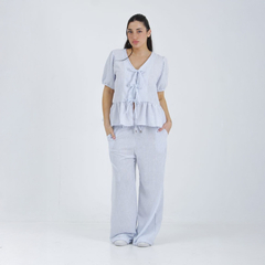 Modelo luciendo una blusa Tulum de rayas con mangas abullonadas y peplum, combinada con pantalones anchos.