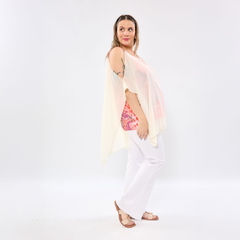 Modelo femenina vistiendo blusa Bella Transfer blanca con diseño liviano y pantalón blanco