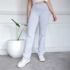 Calza básica recta gris, confeccionada en tela suave, con una modelo que la lleva puesta junto a una planta decorativa en una maceta blanca.