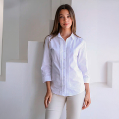 Modelo usando una camisa blanca de estilo clásico con detalles en la parte frontal.