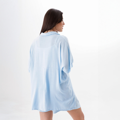 Camisa azul clara de mujer vista desde atrás, con un diseño holgado y cómodo.