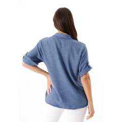Camisa Zahira en color azul, vista posterior, con mangas arremangadas.