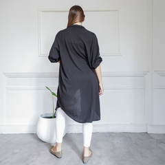 Camisaco Belu negro visto desde atrás, con mangas cortas y detalle de dobladillo, combinado con leggings blancos.