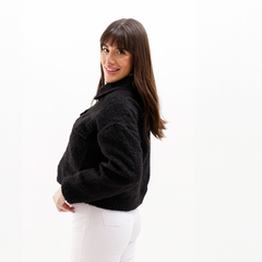 Mujer posando con una campera negra de estilo moderno