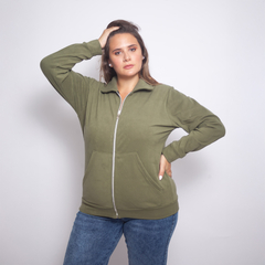 Modelo luciendo una campera Jolie de color oliva con cremallera y bolsillos frontales.