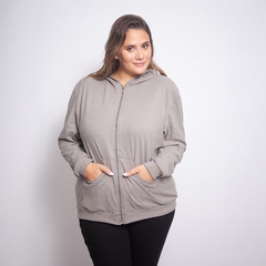 Modelo usando la campera Kala de color gris con capucha y bolsillos frontales.