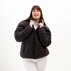 Campera Negma negra de abrigo, con diseño acolchado y cierre, modelada por una mujer.