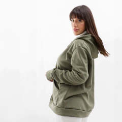 Modelo luciendo una campera verde olivo con capucha, de corte cómodo y moderno.