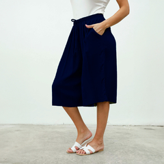 Pantalones Capri Dayak de color azul marino con bolsillos y cintura ajustable, usados por una mujer.